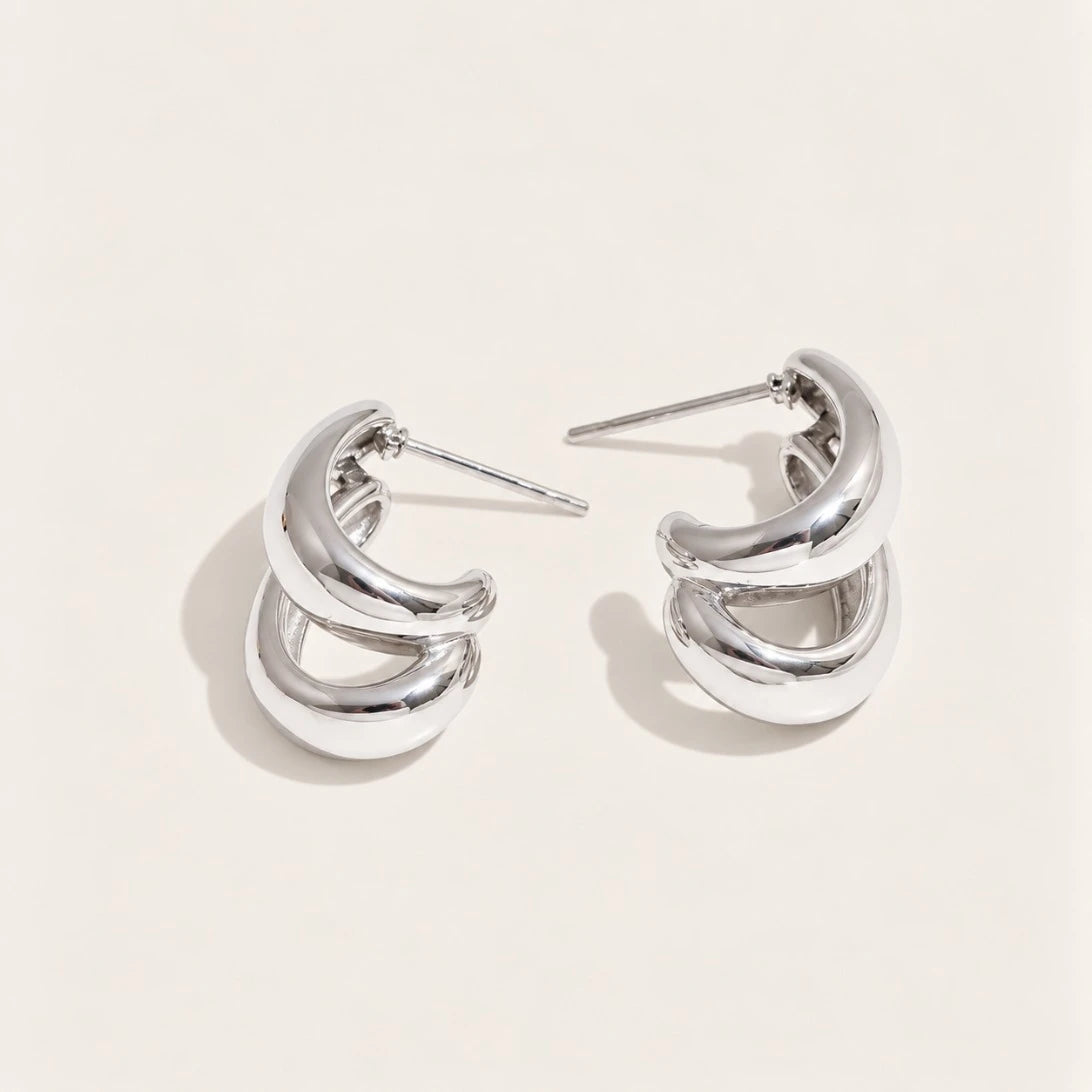 Silver-tone Doppia EARRINGS: a pair of hoops formed by two smooth C-shaped curves layered together — Folie à Trois