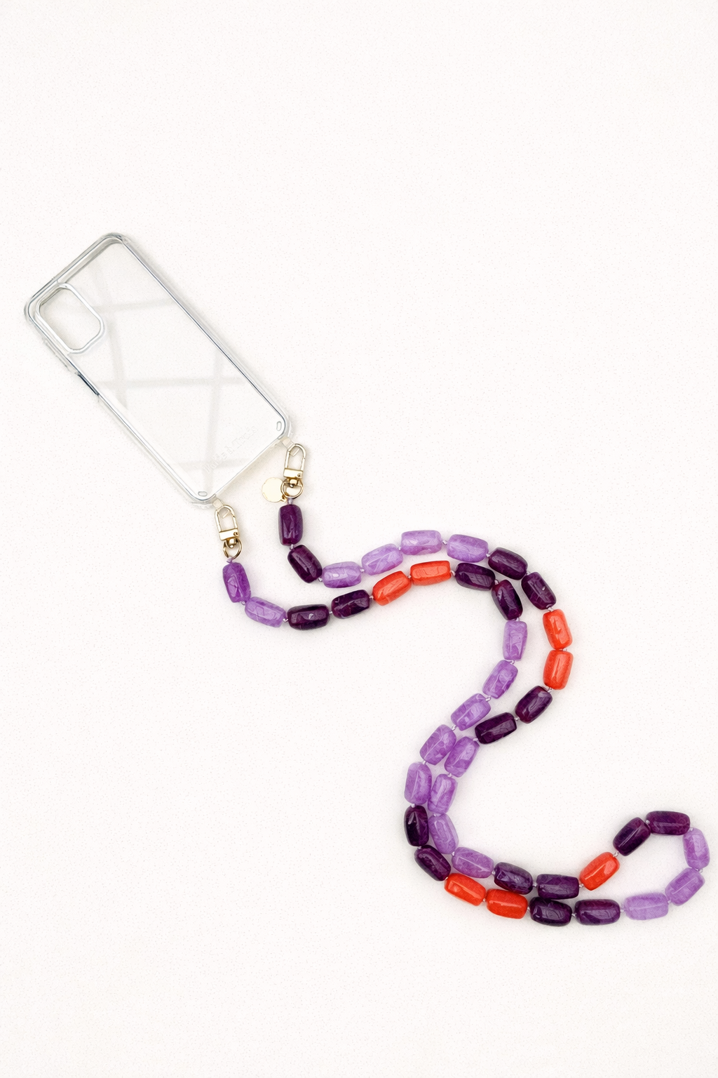 A clear phone case with a purple and orange bead phone chain, shown on a cream background.