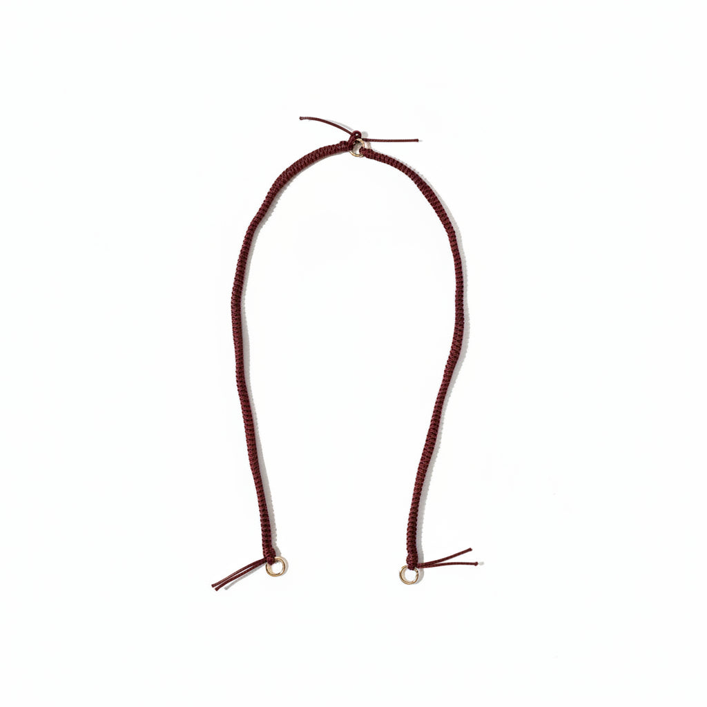 Burgundy braided Layover long phone strap laid out full length on a white background.