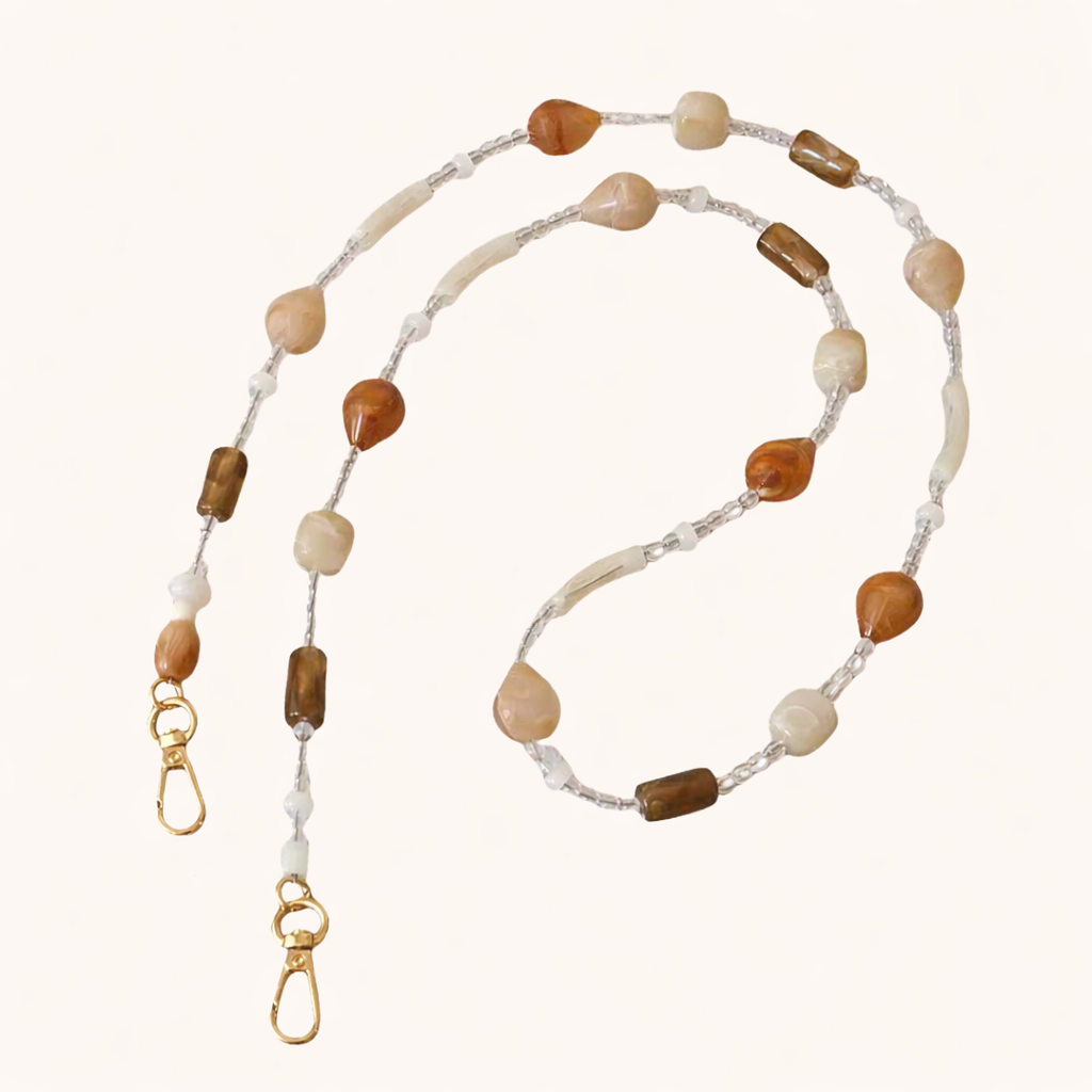 Mixed stone beaded Romee long phone chain in cream, tan, and brown tones, coiled flat with gold clasps.
