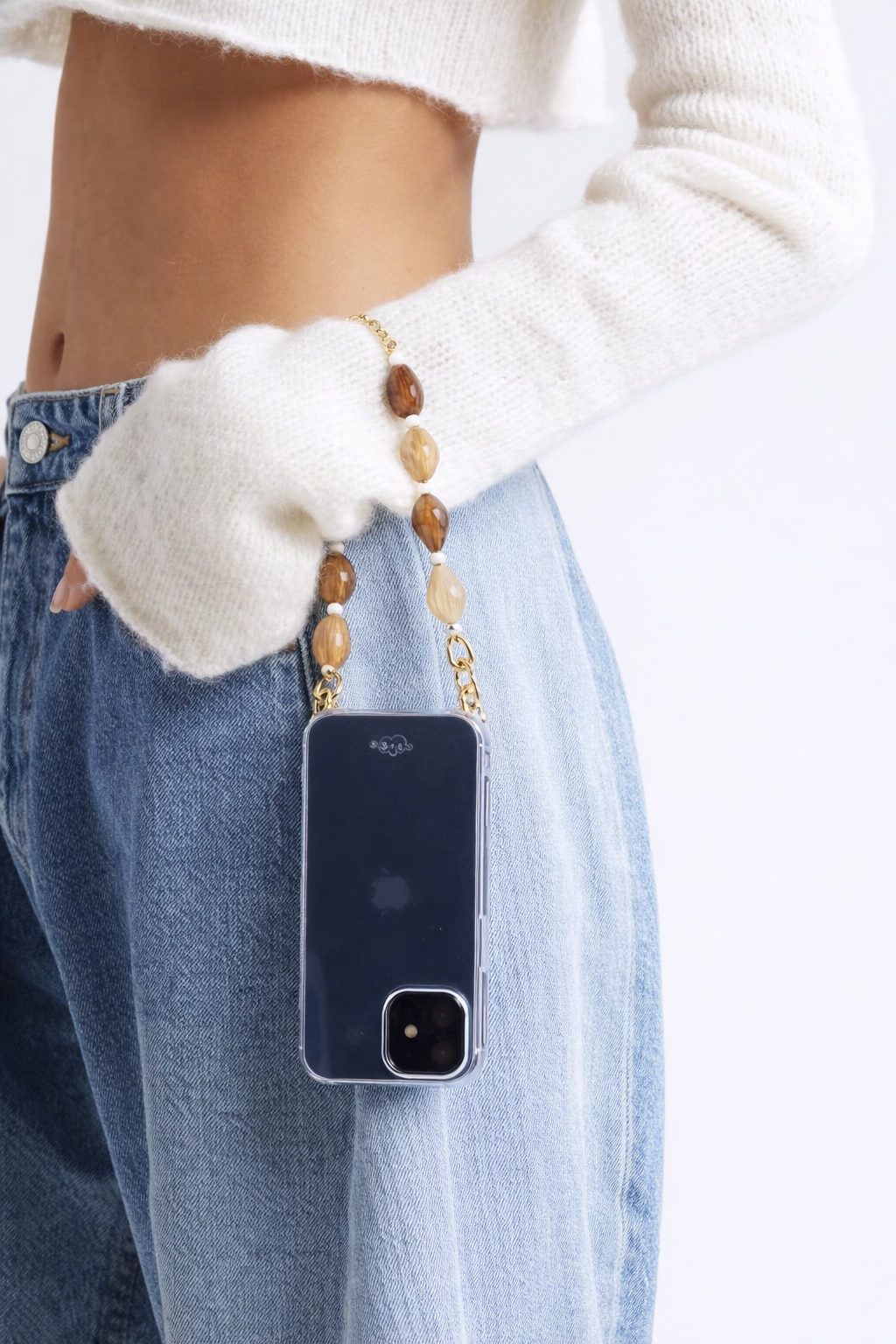 Model holds her phone by the mixed stone beaded Romee strap, phone in a navy case at the hip.