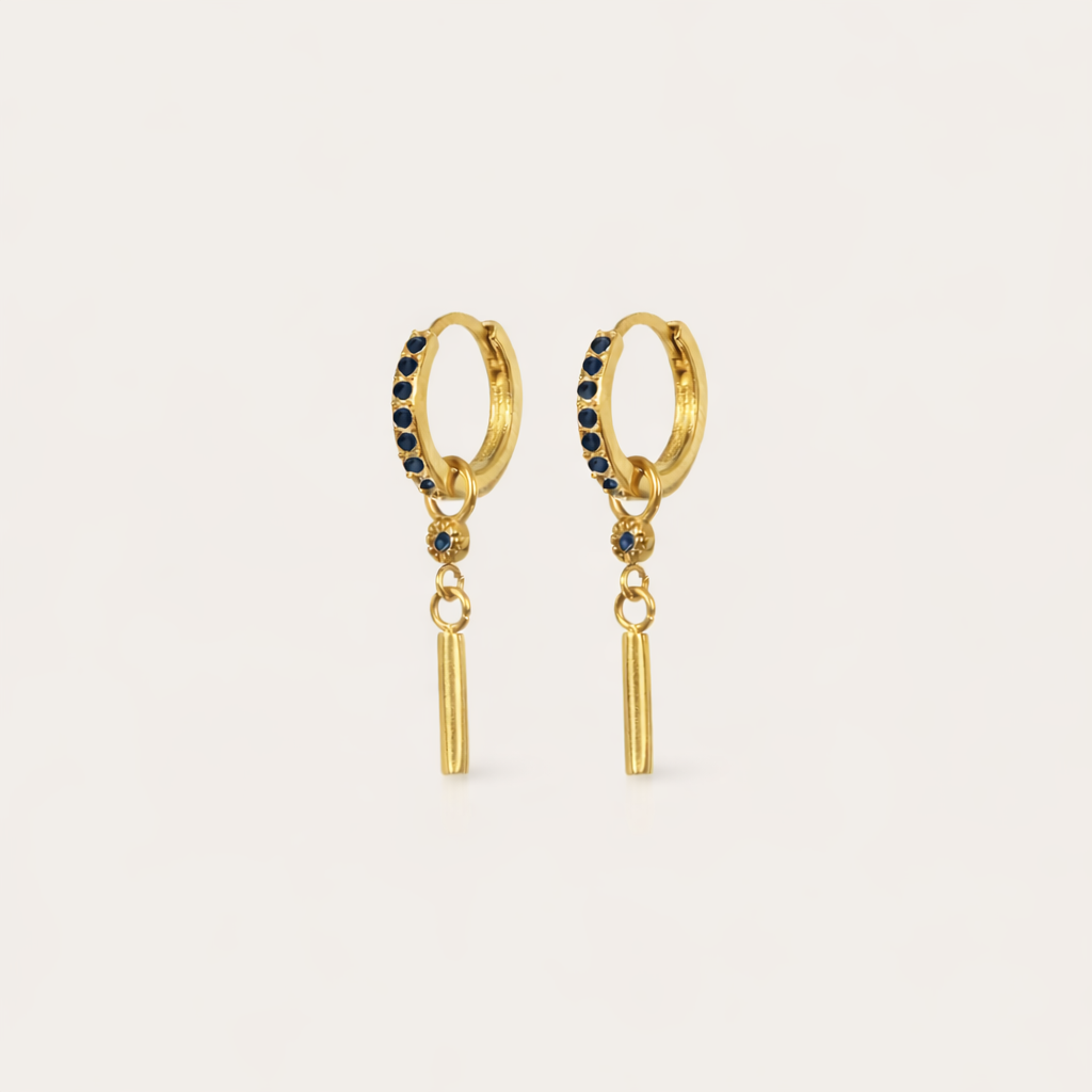 Vibrant Hues Earrings show a deep sapphire-blue pave hoop paired with a slim gold bar charm dangling beneath.