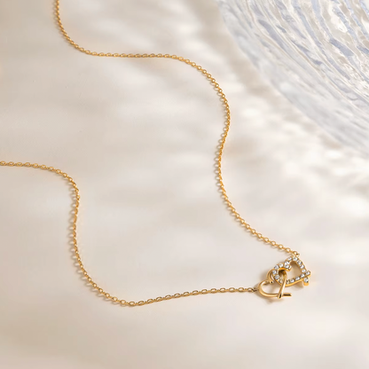 Gold-plated necklace with a delicate chain and interlocking heart-shaped pendant embellished with clear crystals