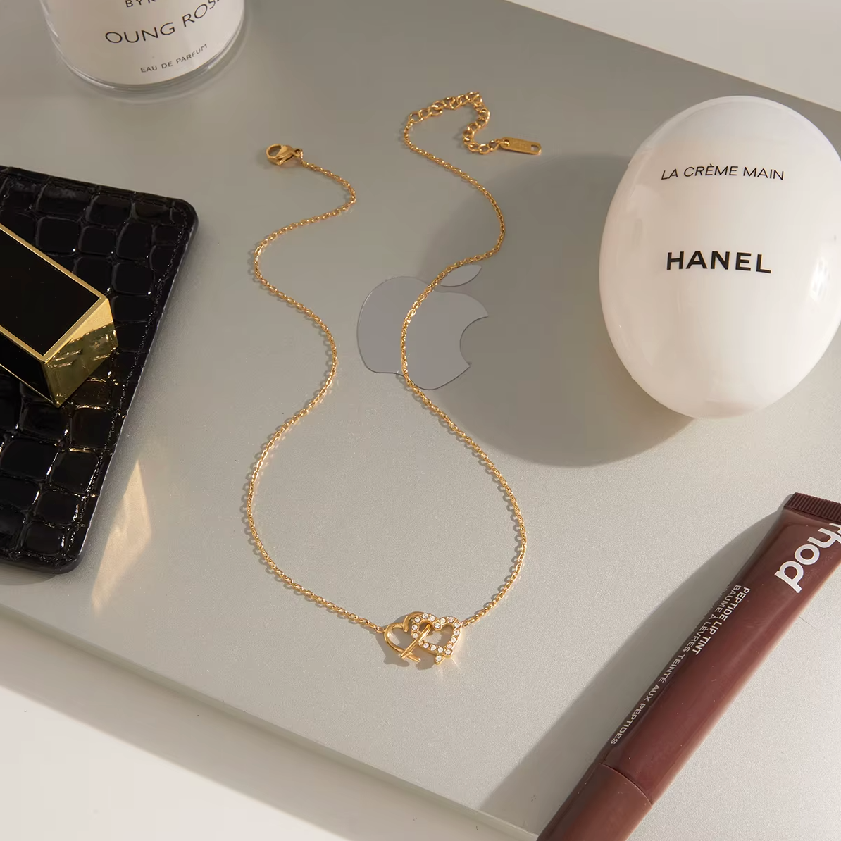 Gold-plated necklace with a delicate chain and interlocking heart-shaped pendant embellished with clear crystals