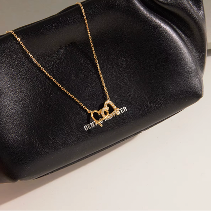 Gold-plated necklace with a delicate chain and interlocking heart-shaped pendant embellished with clear crystals