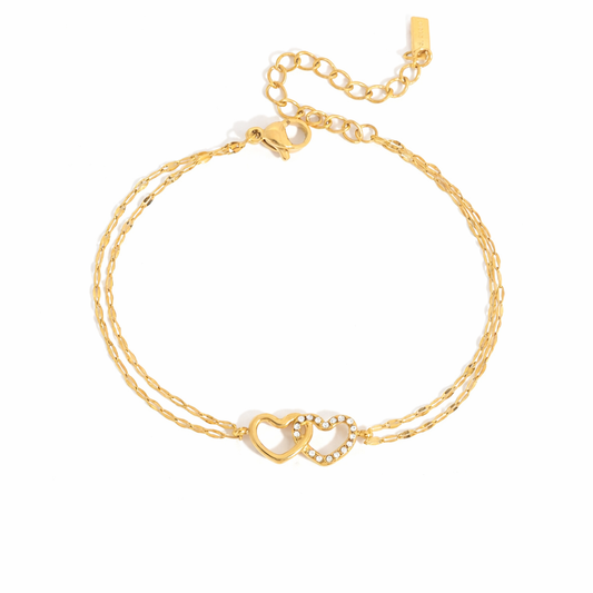 Gold-plated double-chain bracelet with two intertwined heart charms, one polished and one set with clear crystal stones