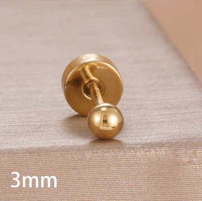 Row of gold ball stud piercings in multiple sizes displayed on a soft fabric background, showing smooth polished finish and flat screw-back closures.