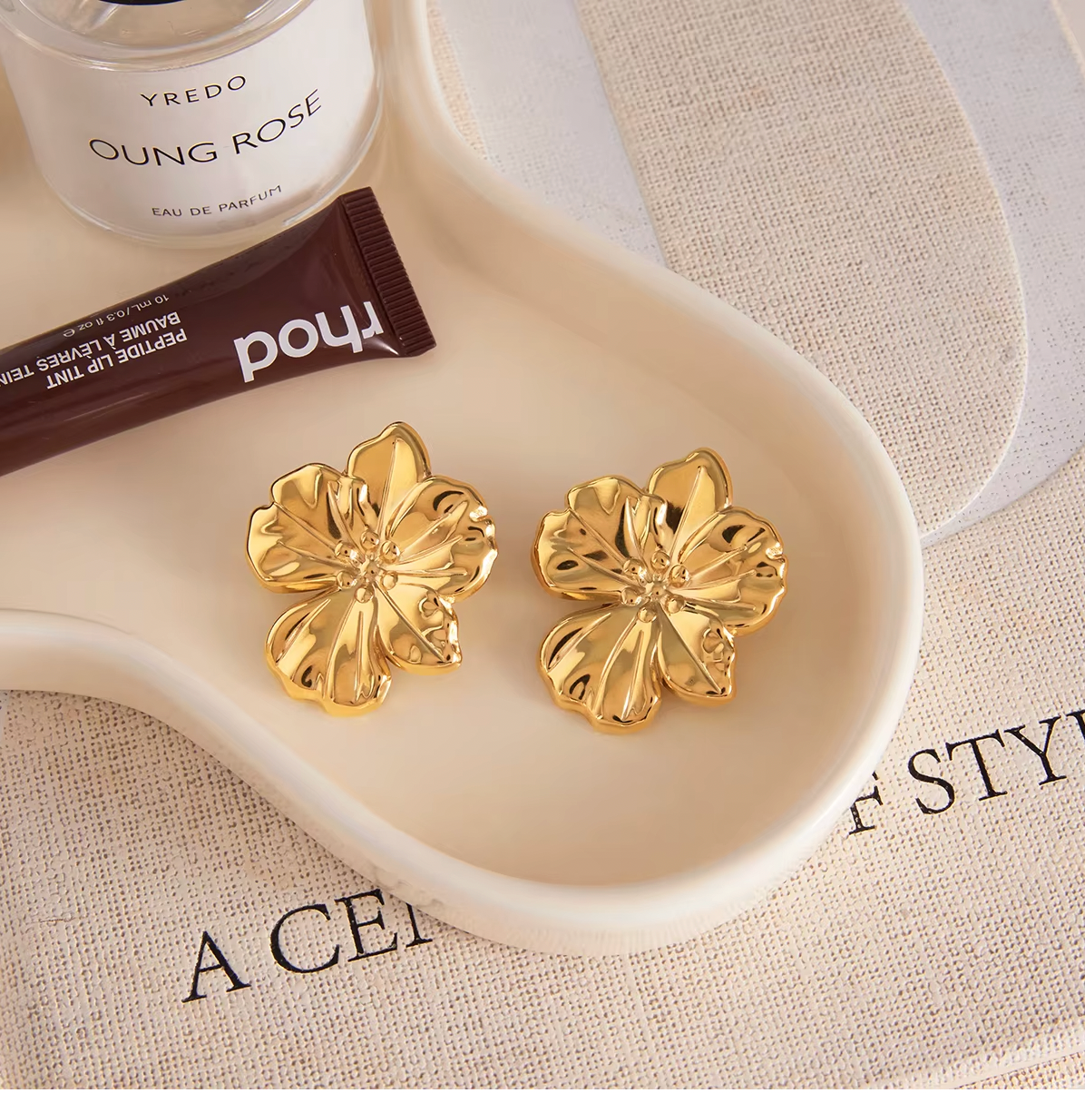 Gold-plated flower-shaped stud earrings with sculpted petals and a polished finish