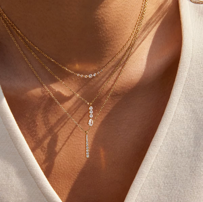 Gold-plated necklace with a fine chain and a slim vertical bar pendant set with clear crystal stones