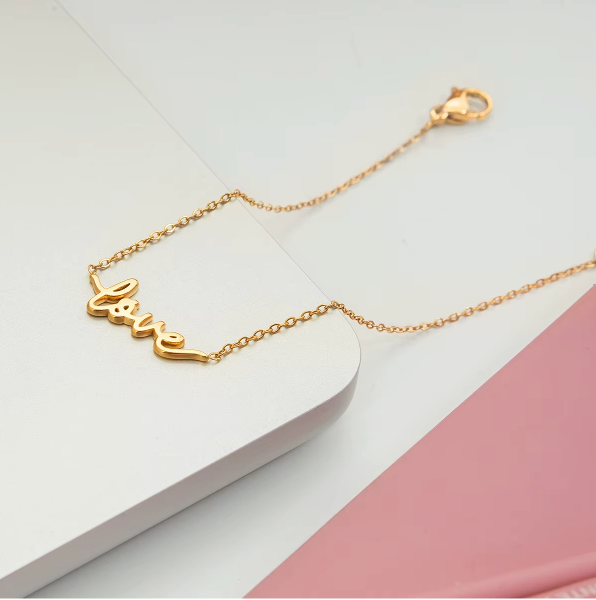 Gold-plated bracelet with a delicate chain and “love” script charm