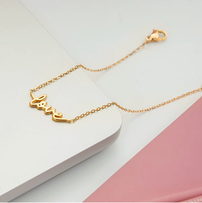 Gold-plated bracelet with a delicate chain and “love” script charm