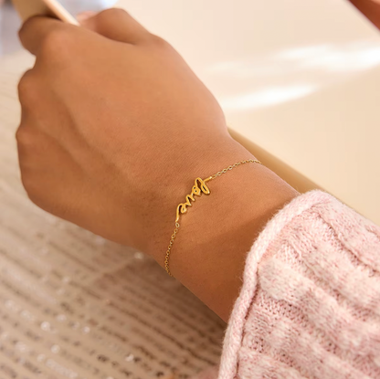 Gold-plated bracelet with a delicate chain and “love” script charm