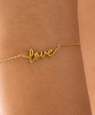 Gold-plated bracelet with a delicate chain and “love” script charm