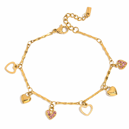 Gold-plated charm bracelet with multiple heart-shaped charms, including open hearts, polished gold hearts, and a pink crystal heart