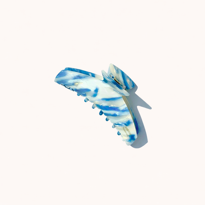 Alba HAIR CLIP wing-shaped acetate claw clip in a blue and white striped pattern, studio shot.