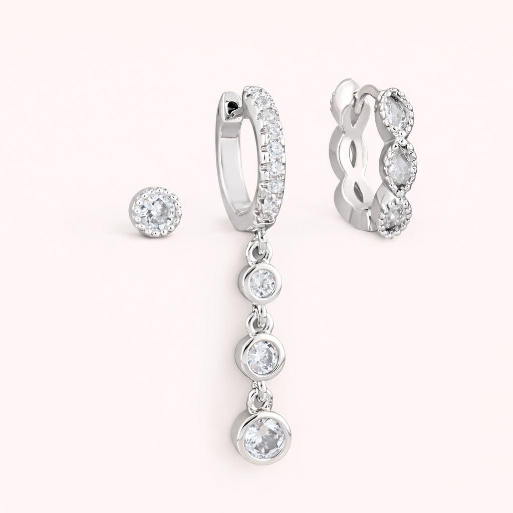 The Amelie SET is shown in silver: a bezel stud, a pave hoop with crystal drops, and a marquise huggie.