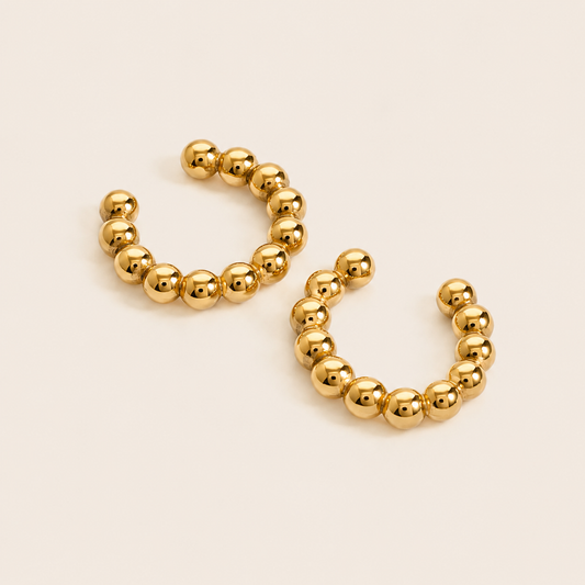 The Antibes EAR CUFF in a pair, a gold beaded cuff made of small polished spheres following the ear cartilage curve.