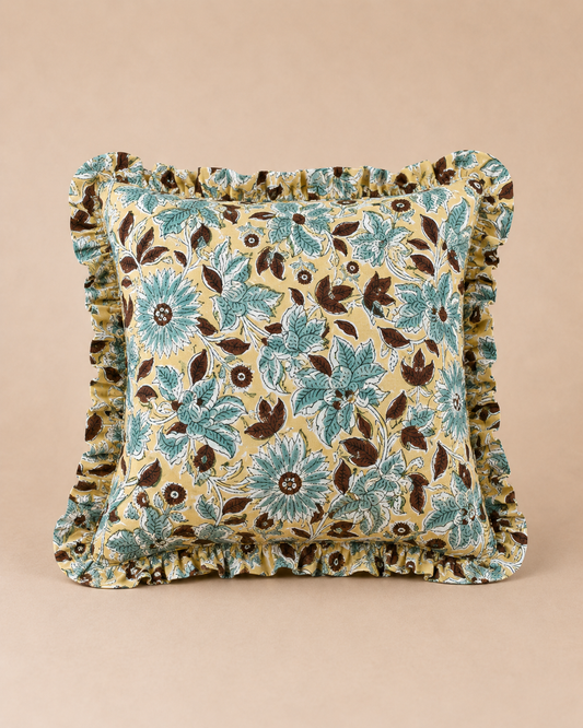 Aqua Blossom Square cushion in mustard yellow with a teal and brown block-print floral pattern, finished with a matching ruffled trim.