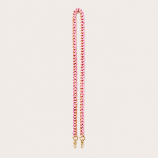 Folie à Trois Aspen long wholesale phone strap in pink and gold woven curb chain with gold clasps, laid straight on a cream background.