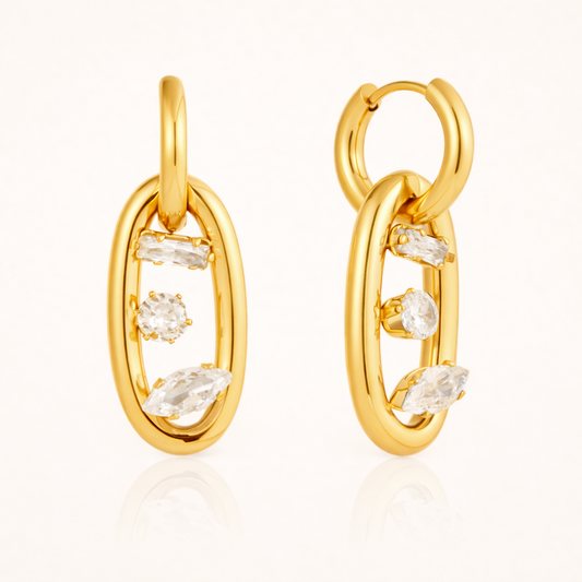 The Astral EARRINGS pair an open gold hoop with an oval link set with baguette, round, and marquise crystals.