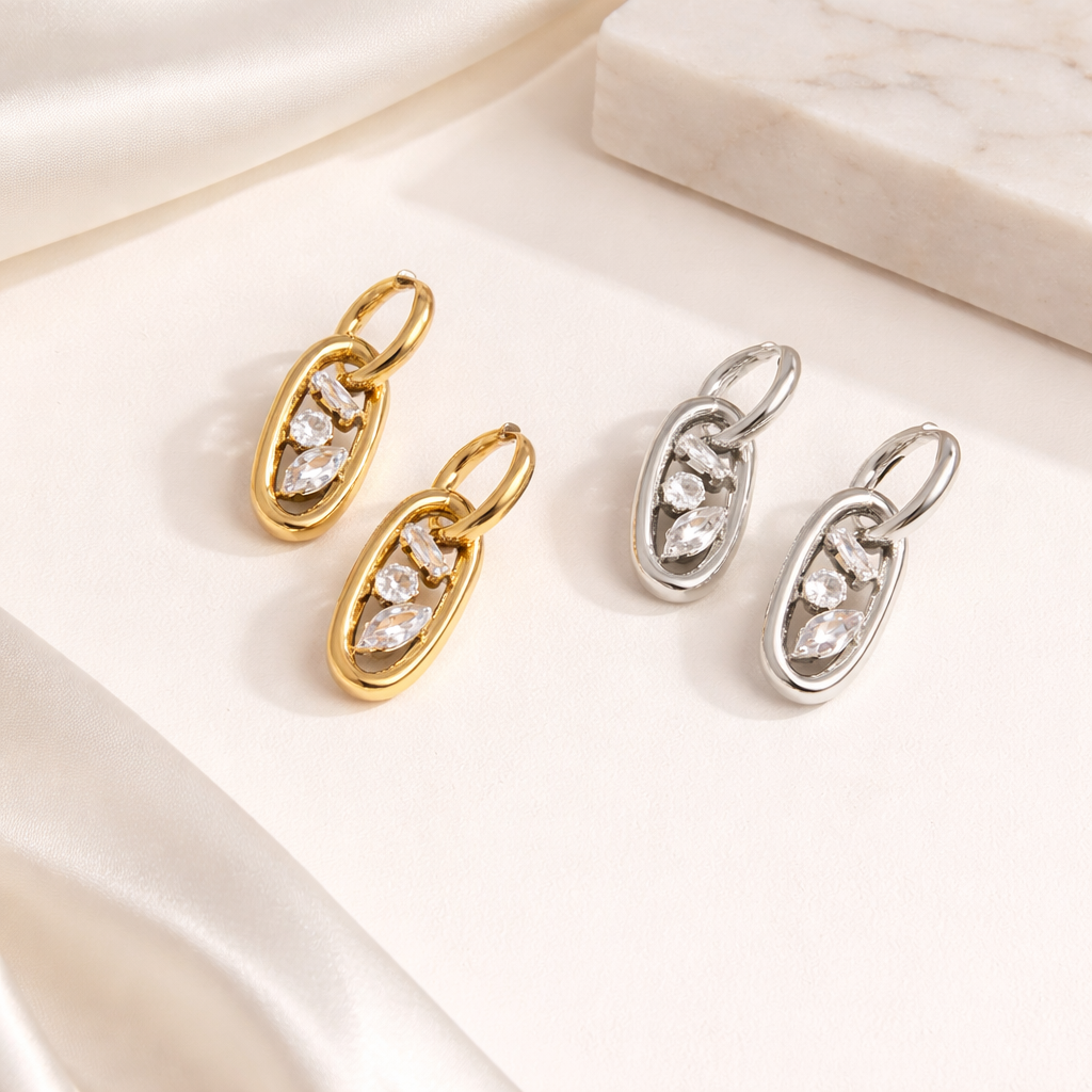 Gold and silver versions of the Astral EARRINGS are styled together, each with a crystal-set oval link.