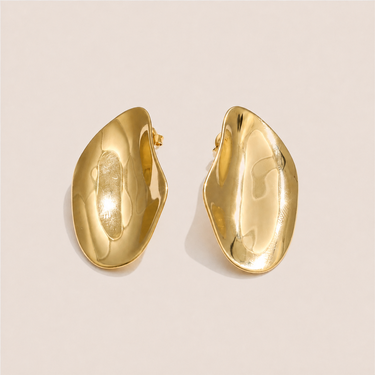 Gold sculptural asymmetric dome stud earrings with a hammered, wavy organic shape on a cream backdrop — Folie à Trois Axis EARRINGS
