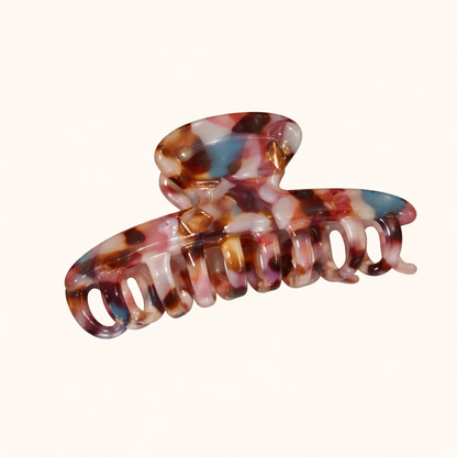 Pink, blue and brown speckled tortoiseshell acetate claw clip from the Baby Love HAIR CLIP collection, on a cream studio background.