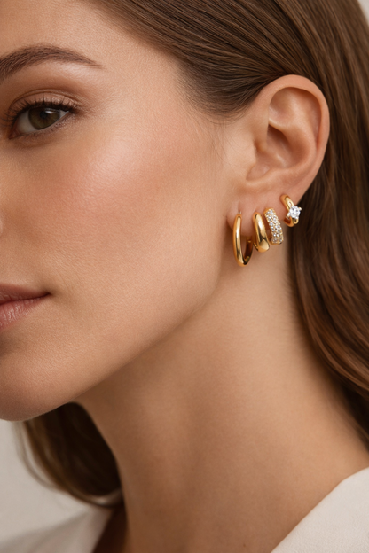 Close up on the ear, the Belle SET shows its four stacked gold hoops, one edged with sparkling pave crystals.