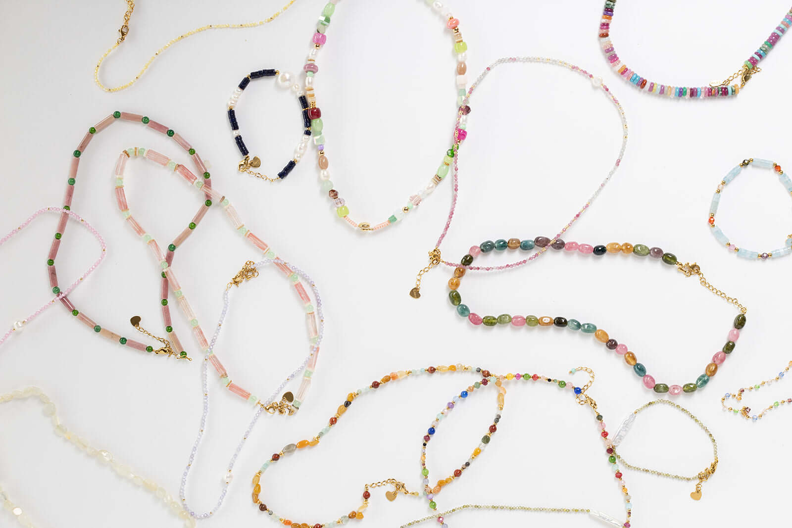 Bianca BRACELET pink and white beaded pieces shown within a wider flat-lay of assorted beaded jewelry.