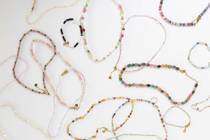 Bianca BRACELET pink and white beaded pieces shown within a wider flat-lay of assorted beaded jewelry.