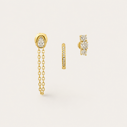 Gold earring set with a pear-cut zirconia chain-drop stud, a pavé huggie hoop, and a three-stone climber stud — Folie à Trois Bijou SET.
