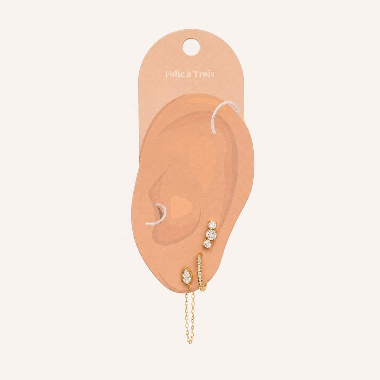 Folie à Trois Bijou SET displayed on a branded ear-shaped card, showing the stud, pavé hoop and chain-drop placement.