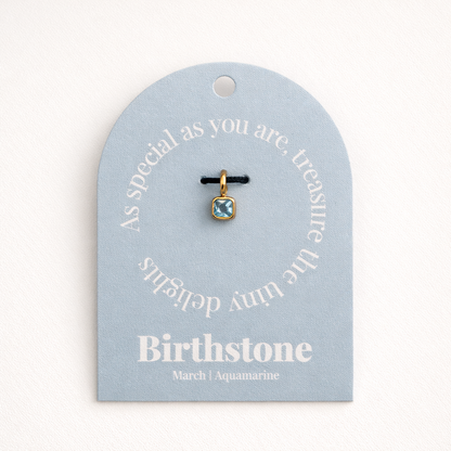 The Birthstone Charm BUNDLE in March Aquamarine, a second view of the pale blue square charm on its light blue Birthstone gift tag.