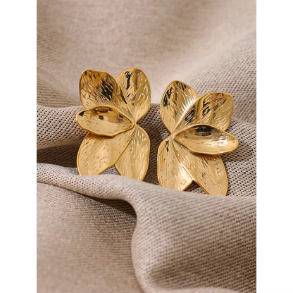 Bloom Earrings in gold styled on woven fabric from another angle, showing the layered flower petal shape.