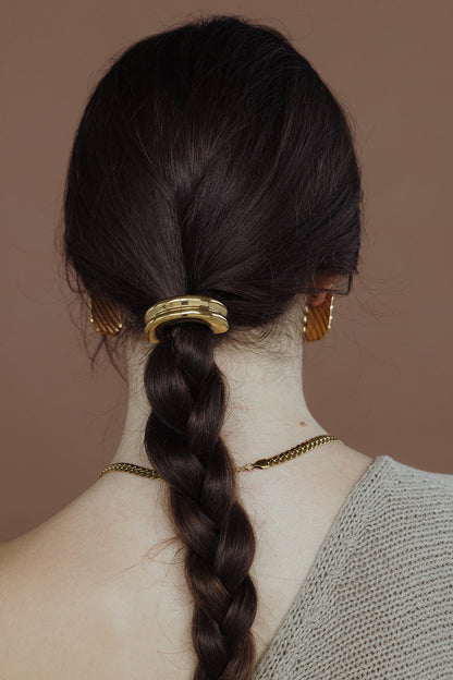 Bridgette Hair Tie worn on a braided ponytail, ridged gold bead accent, model in a knit sweater.