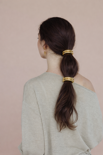 Bridgette Hair Tie worn stacked, two ridged gold beads down a low ponytail, sage green sweater.