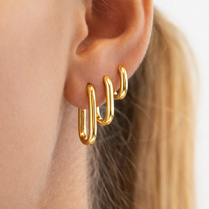 Bruna Set worn on the ear in gold, three rectangular oval hoops stacked from smallest to largest size.