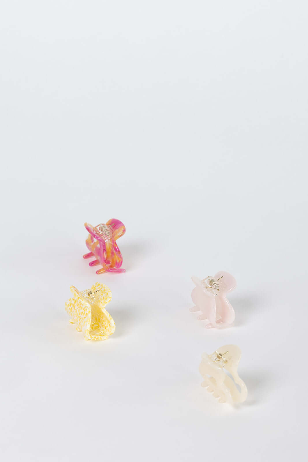 Bubblegum HAIR CLIP four small claw clips shown together in pink-orange, yellow, pale pink and cream colorways, studio shot.