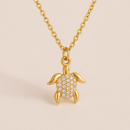 The By The Sea NECKLACE in the pave turtle style, worn close-up with its crystal-set shell catching light against a bare neckline.