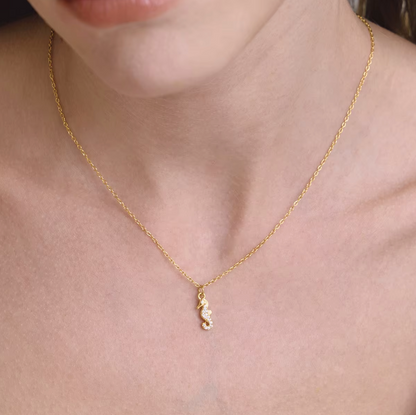 The By The Sea NECKLACE in the pave seahorse style, worn close-up at the collarbone on a fine gold chain.