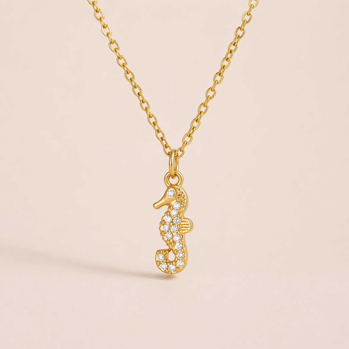The By The Sea NECKLACE in the pave seahorse style, hanging against a plain beige background to show its crystal detailing.