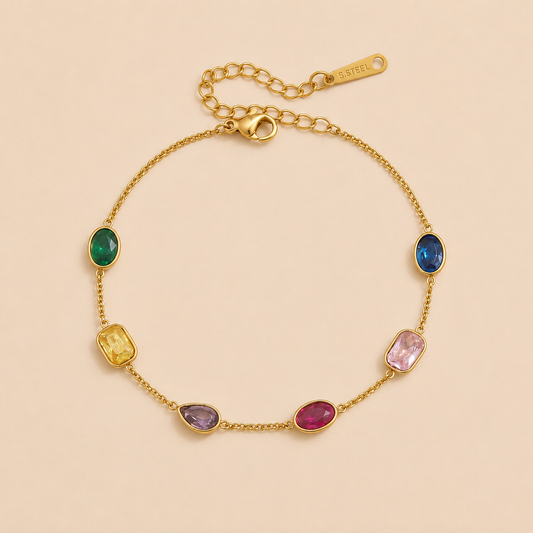 Calma BRACELET in gold with multicolored faceted gemstones in oval, cushion, and pear cuts set along a chain, shown flat.