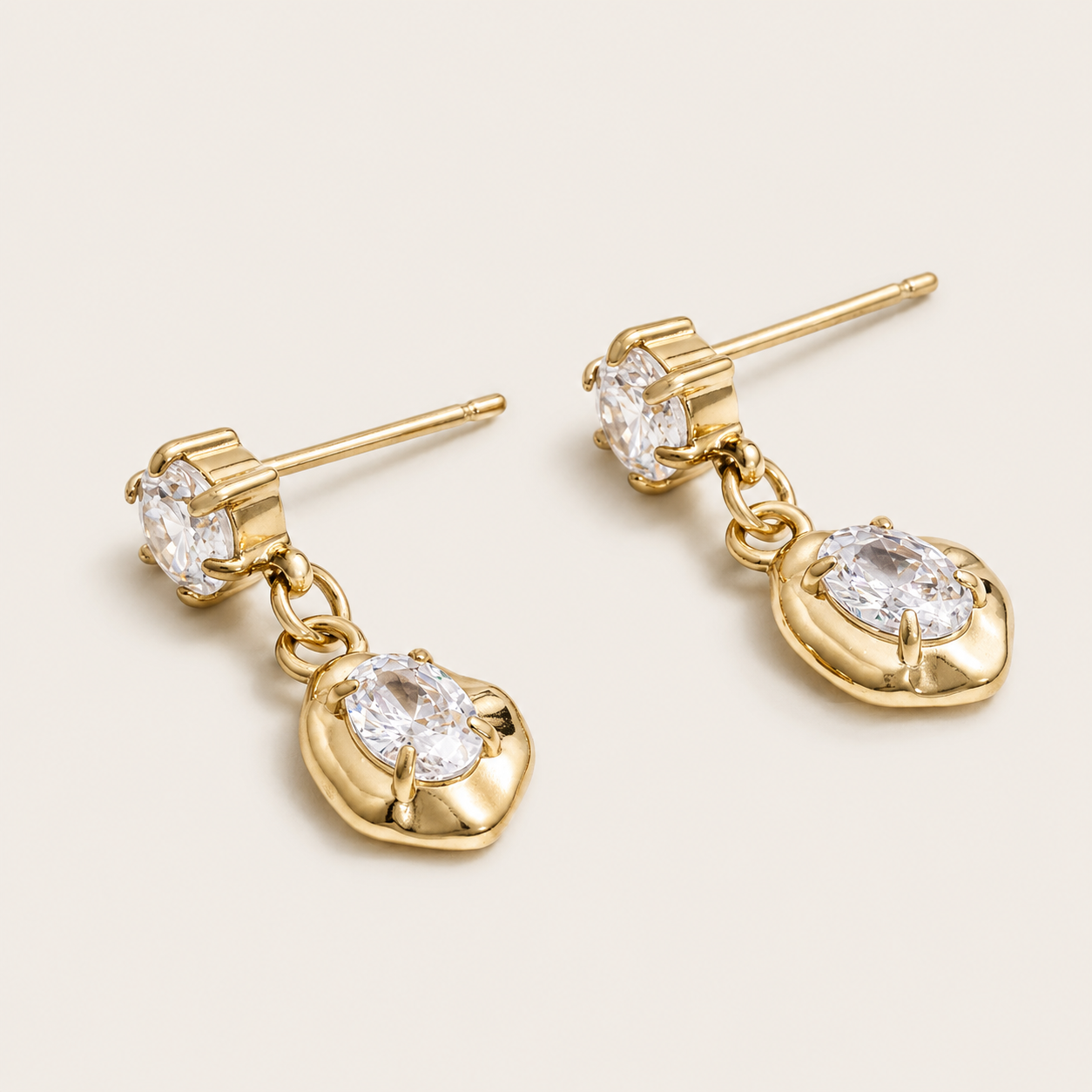 Gold drop earring with a round zirconia stud and an oval zirconia set in a sculpted heart-shaped bezel — Folie à Trois Cameo EARRINGS.
