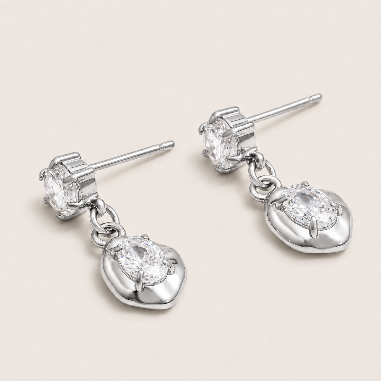 Silver drop earring with a round zirconia stud and an oval zirconia set in a sculpted heart-shaped bezel — Folie à Trois Cameo EARRINGS.