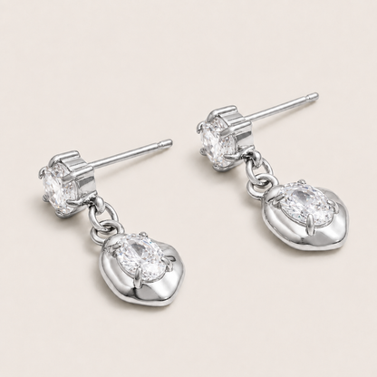 Silver drop earring with a round zirconia stud and an oval zirconia set in a sculpted heart-shaped bezel — Folie à Trois Cameo EARRINGS.