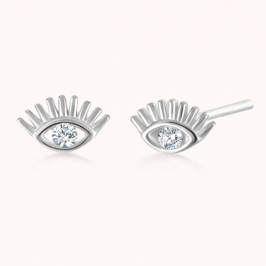Captured In Your Eyes Earrings shape a silver evil-eye stud with lash-like rays and a sparkling clear center stone.