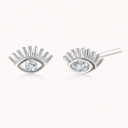 Captured In Your Eyes Earrings shape a silver evil-eye stud with lash-like rays and a sparkling clear center stone.