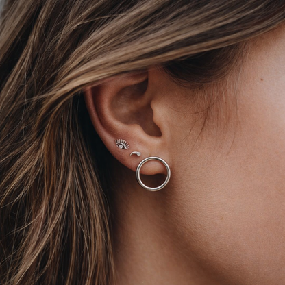 Worn layered along the ear, Captured In Your Eyes Earrings pair the eye stud with a moon stud and a large hoop.