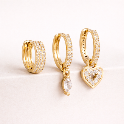 The Cara SET includes three gold huggie hoops, one pave-lined, with a marquise crystal drop and a pave heart charm.