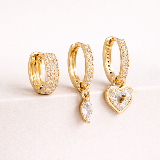 The Cara SET includes three gold huggie hoops, one pave-lined, with a marquise crystal drop and a pave heart charm.